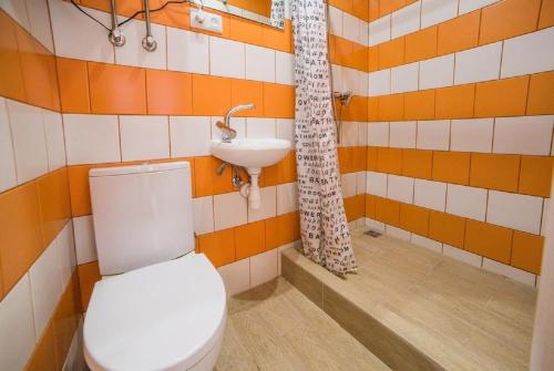 y baño con aseo y lavamanos. en Smart-апартаменти в центрі Львова, en Leópolis