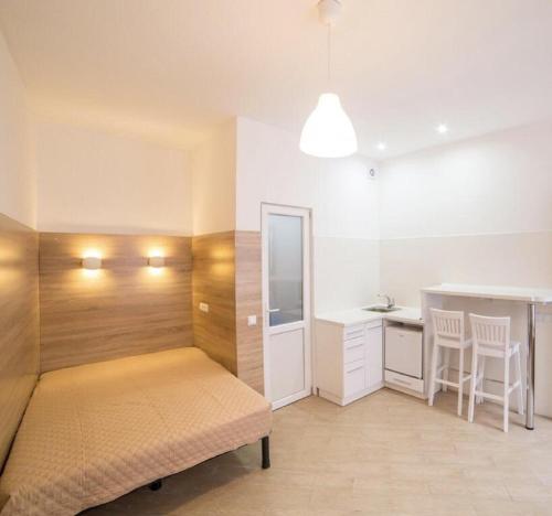 1 dormitorio con cama, mesa y barra en Smart-апартаменти в центрі Львова, en Leópolis