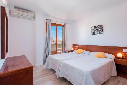 a white room with a bed and a window at Apartamento Bressol D in Port de Pollensa