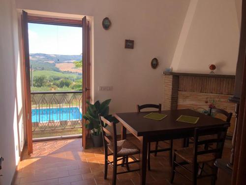 a dining room with a table and a view of a pool at Gorgeous 2-storey villa with a large private pool in Todi