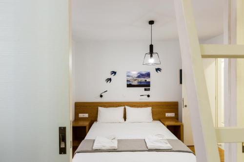 a bedroom with a bed and a pendant light at Ink Hotels Phos in Rethymno
