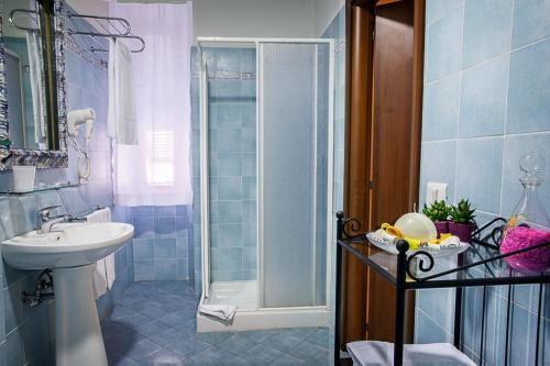 y baño azul con lavabo y ducha. en Camere Del Re, en Tarquinia