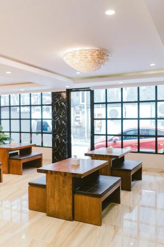 a restaurant with tables and benches and windows at Barelang Hotel Nagoya Batam in Nagoya