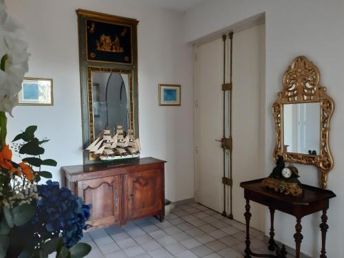 Cette chambre comprend un miroir et une commode en bois. dans l'établissement Sun Beam Cannes, à Cannes