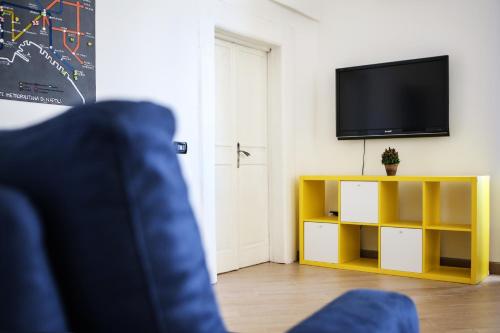 ein Wohnzimmer mit einem TV und einem gelben Schrank in der Unterkunft Casa Milì by Wonderful Italy in Neapel