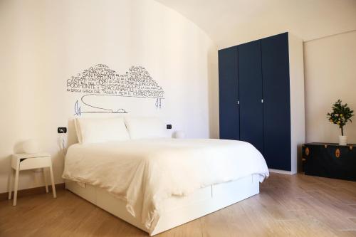 ein Schlafzimmer mit einem weißen Bett und einem blauen Schrank in der Unterkunft Casa Milì by Wonderful Italy in Neapel