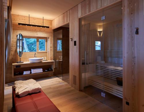 a bathroom with a shower and a sink and a tub at ADLER Lodge RITTEN in Soprabolzano