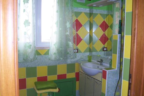 a colorful bathroom with a sink and a window at B&B Le Terrazze Isola Di S. Antioco in SantʼAntìoco