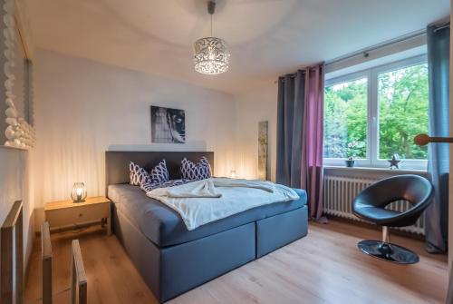 a bedroom with a bed and a chair and a window at Apartmenthaus am Erlbach in Buch am Erlbach