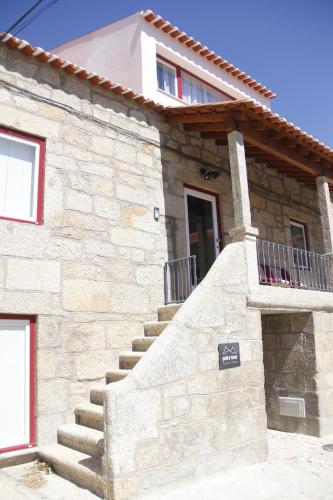 a stone house with stairs in front of it at Pedra Nova in Castelo Novo