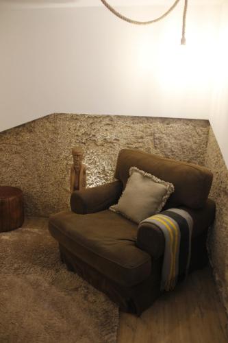 a brown couch with a pillow in a room at Pedra Nova in Castelo Novo