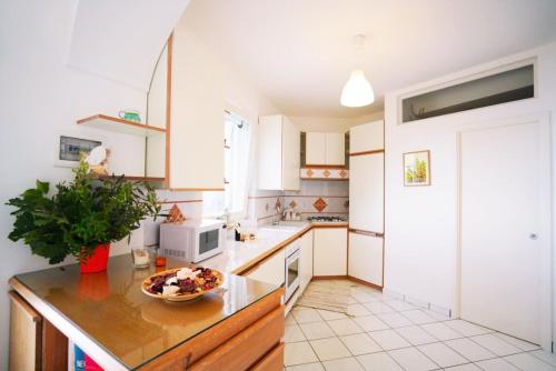 a kitchen with white cabinets and a bowl of food on a counter at La Casetta delle Api in Capri