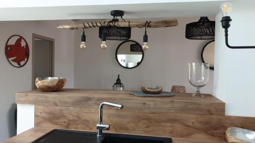 a kitchen with a counter with a sink and a mirror at Rélocation vacances de la cote sauvage in Saint-Clément-des-Baleines