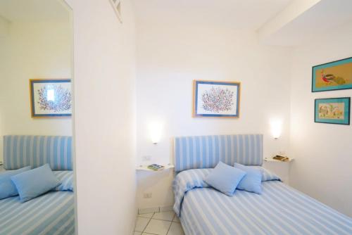 two beds in a room with blue pillows at La Casetta delle Api in Capri