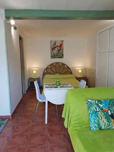 een slaapkamer met een bed en een tafel en stoelen bij studio Côté Sud vert in Sarlat-la-Canéda