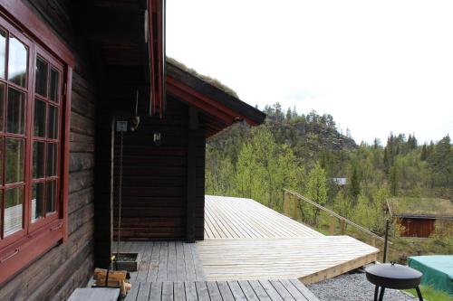 een houten veranda van een hut met een houten terras bij Lillesander - 3 bedroom cabin in Al