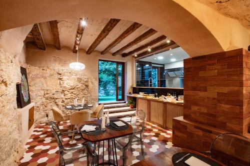 a kitchen and dining room with a stone wall at El Palauet del Priorat in Cornudella