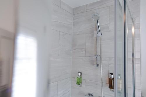 a shower in a bathroom with a glass door at The Wheatsheaf Pub, Kitchen & Rooms in Bingham