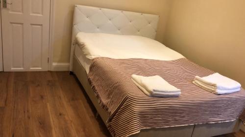 a bed with two white towels on top of it at Camden SUITES in London