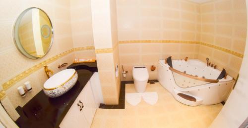 a bathroom with a tub, sink and toilet at Ruvisha Beach Hotel in Negombo