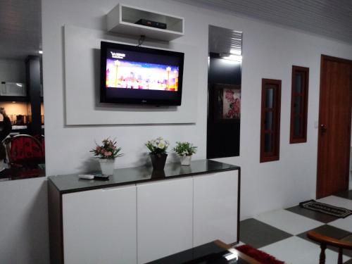 uma sala de estar com uma televisão na parede em Sossego de Gramado em Gramado