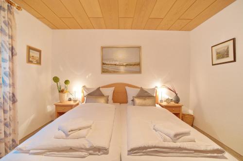 sypialnia z dużym białym łóżkiem z 2 stolikami nocnymi w obiekcie Ferienwohnung Ostrach w mieście Sonthofen