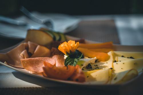 a plate of cheese and fruit on a table at WURZENBERG Hotel Lodges Südsteiermark in Gamlitz