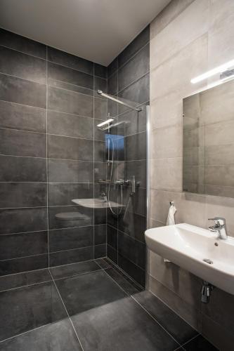a bathroom with a sink and a shower at Penzión Imperial in Žarnovica