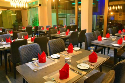 a restaurant with tables and chairs with red napkins on them at Ruvisha Beach Hotel in Negombo