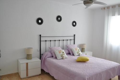 a bedroom with a bed and two mirrors on the wall at Alenia Apartments in Alicante