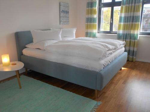 uma cama num quarto com uma vela sobre uma mesa em Design Apartments - "Am Schlosspark" Adults Only em Potsdam