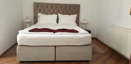 1 dormitorio con 1 cama blanca grande con sábanas blancas en Pensiunea Mayumi Moneasa en Moneasa