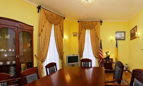 a dining room with a table and chairs and a television at Hotel Star in Mukacheve