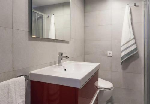 a bathroom with a white sink and a toilet at Pine Paradise by Seasidehomes in Gavà