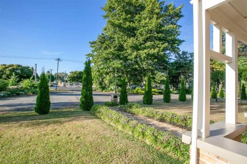 a row of cypress trees on the side of a street at Penmarric House - Self Check-in in Cambridge