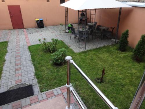 eine Terrasse mit einem Tisch, Stühlen und einem Sonnenschirm in der Unterkunft Apartamenty NOCLEGI BĘDZIN in Będzin