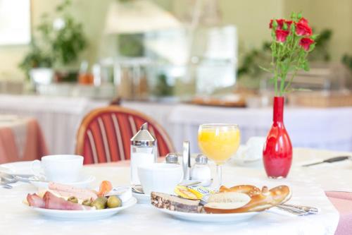 a table with a plate of food and a glass of orange juice at Apartments Drei Morgen in Leinfelden-Echterdingen