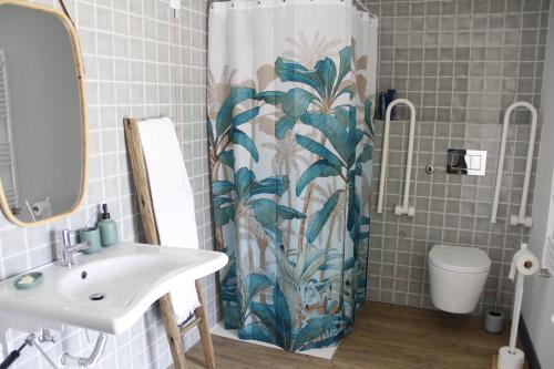 a bathroom with a shower curtain with a sink and a toilet at Pedra Nova in Castelo Novo