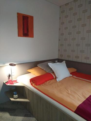 a bedroom with a large bed with a lamp on it at Business Apartments in Hohenems