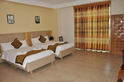 pokój hotelowy z 2 łóżkami i oknem w obiekcie Mekelle Hotel w Mekelie