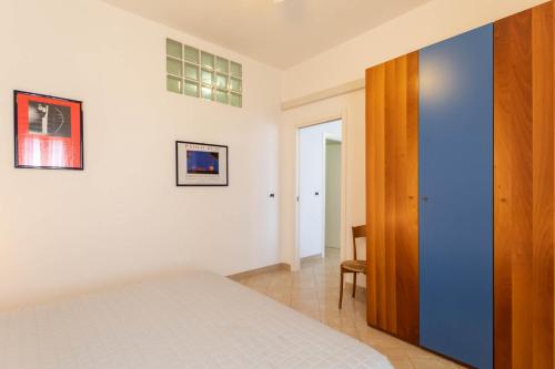 a bedroom with a blue wall and a white bed at Residenza Adelaide in Finale Ligure