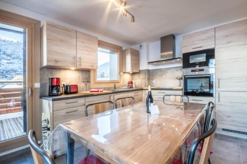 une grande cuisine avec une table et des chaises en bois dans l'établissement JOUX PLANE A 202, à Morzine