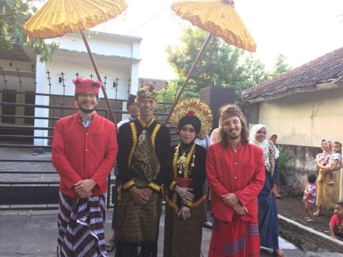 a group of people posing for a picture under umbrellas at Tereng Wilis Jungle Inn in Tetebatu