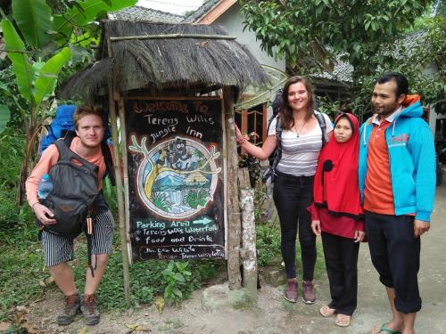 a group of people standing in front of a sign at Tereng Wilis Jungle Inn in Tetebatu