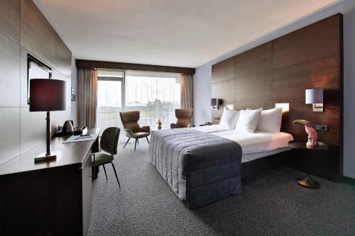 Habitación de hotel con cama y escritorio en Van der Valk Hotel Sassenheim - Leiden, en Sassenheim