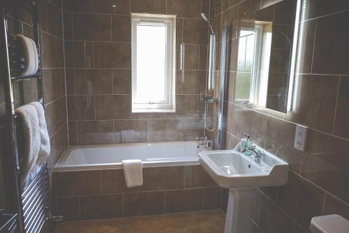 a bathroom with a bath tub and a sink at The Mill at Conder Green in Conder Green