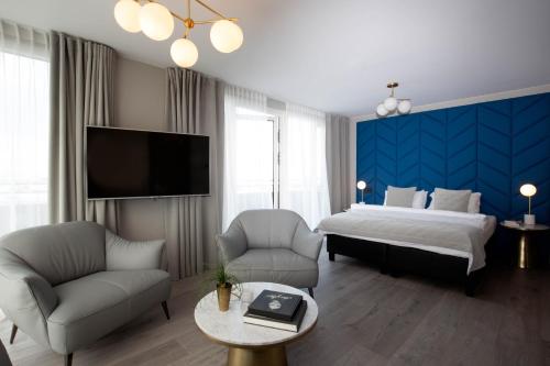 1 dormitorio con 1 cama, 2 sillas y TV en Midtown Hotel en Reikiavik