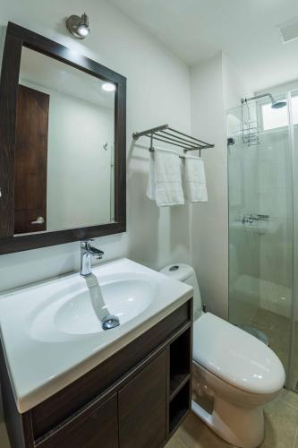 a bathroom with a sink and a toilet and a mirror at Altoprado Popayán in Popayan