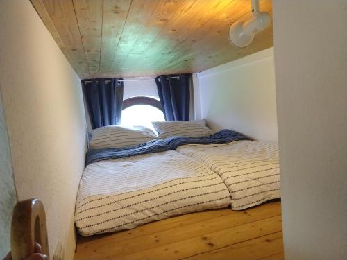 uma cama num pequeno quarto com uma janela em Piratennest em Sankt Peter-Ording