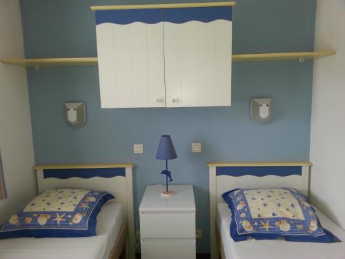 - une chambre avec 2 lits et une armoire blanche dans l'établissement REF 060 Appartement pour quatre personnes résidence avec piscine vue Port Crouesty ARZON, à Arzon